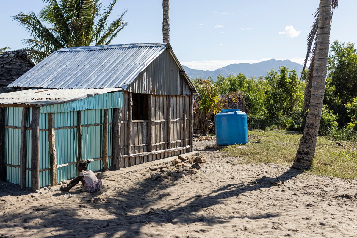 A girl plays next to a water tank supplied by Rio Tinto to Emanakana village on the shores of Lake Lanirano in Fort-Dauphin, Madagascar, on July 9, 2023. Employees come few times a week to fill up the tanks ever since people were discouraged to drink water from the lakes.