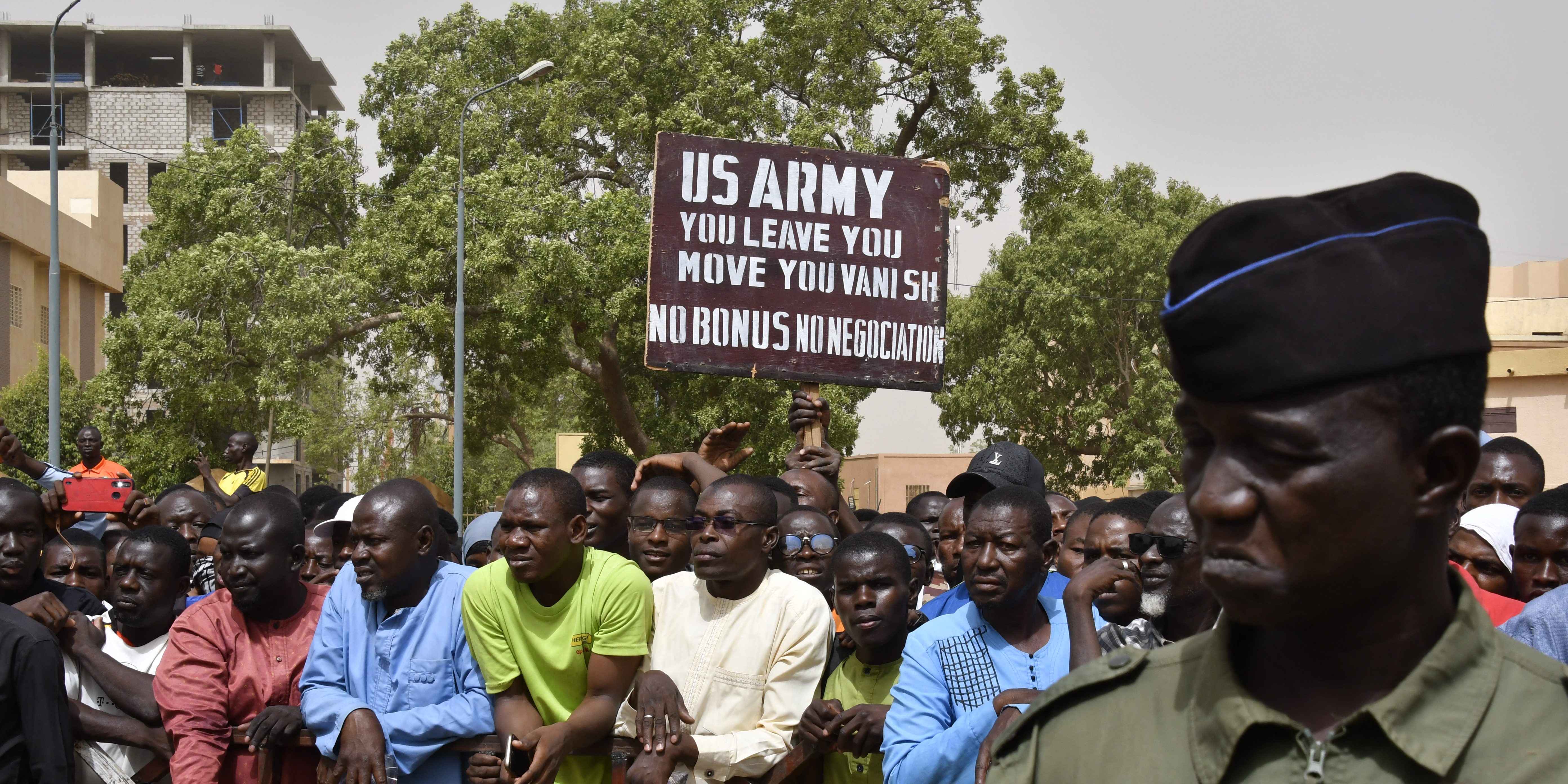 Protesters gather as a man holds up a sign demanding that soldiers from the United States Army leave Niger without negotiation during a demonstration in Niamey, on April 13, 2024. Thousands of people demonstrated on April 13, 2024 in Niger's capital Niamey to demand the immediate departure of American soldiers based in northern Niger, after the military regime said it was withdrawing from a 2012 cooperation deal with Washington. (Photo by AFP) (Photo by -/AFP via Getty Images)